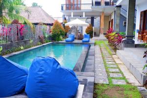 a swimming pool with blue inflatables in front of a house at D'Canggu Homestay in Canggu