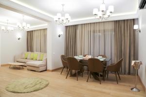 a dining room with a table and a couch at Expecto Apartments in Sinaia