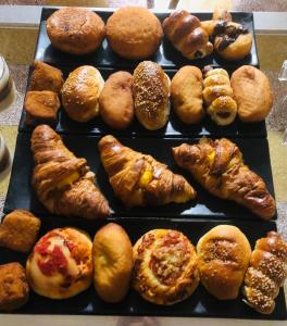 Una bandeja con diferentes tipos de pasteles y croissants. en B&B Giulio Cesare 24, en Palermo