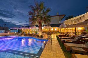 a swimming pool with lounge chairs and a palm tree at Principal New Leisure Hotel in Paralia Katerinis