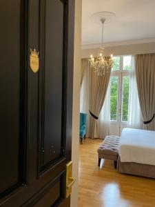 een slaapkamer met een bed en een kroonluchter bij Athens Mansion Luxury Suites in Athene