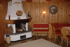 a room with a fireplace and two chairs and a table at Pension Sunnbichl in Going am Wilden Kaiser