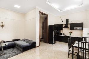a living room with a couch and a kitchen at Katerynynska Prestige Apartment in Odesa
