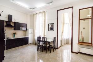 a kitchen and dining room with a table and chairs at Katerynynska Prestige Apartment in Odesa