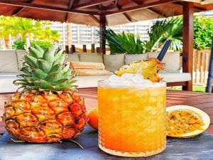 a pineapple sitting on a table next to a drink at Sunset Balcony with Ocean Views and pool access in Mogán