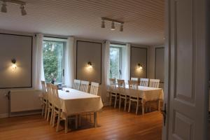 una sala da pranzo con tavoli, sedie e finestre di Aagaard a Grenå