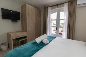 a bedroom with a bed with a television and a window at Caribbean Estates - 35 Montego Bay by Luxe in Port Edward +28 photos