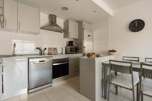 a kitchen with white appliances and a table with chairs at Aquamarina Beach in Alcudia