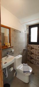 a bathroom with a white toilet and a sink at Amoraninew in Batsi
