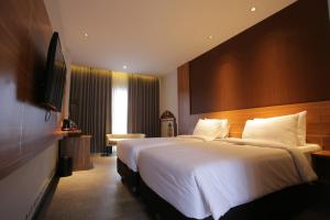 a hotel room with a large bed and a television at Creative Restart Hotel - CARTEL Bandung in Bandung