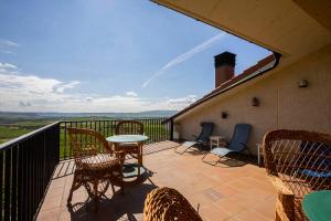 a patio with chairs and a table on a balcony at Mar de viñas in San Asensio