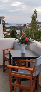 una mesa y sillas con flores en el balcón en Amoraninew, en Batsi