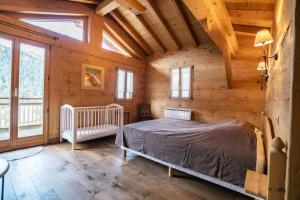 ein Schlafzimmer mit einem Bett in einer Holzhütte in der Unterkunft Chalet LouBochu Châtel Réservation in Châtel