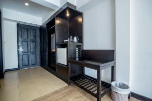 a kitchen with a black counter and a refrigerator at Sea Breeze Jomtien Resort in Jomtien Beach