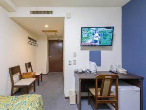 a hospital room with a desk and a tv on the wall at Hotel Koryukaku in Tokyo
