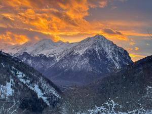 a snow covered mountain with a sunset in the background at Le Nid in Vaujany
