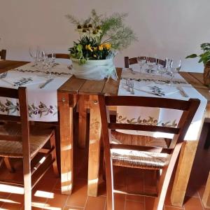 un tavolo in legno con sedie e un vaso di fiori di Fattoria di Cintoia a Pontassieve