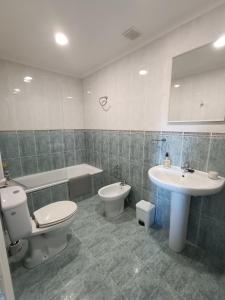 een badkamer met een toilet, een bidet en een wastafel bij Bonito duplex cerca de la playa y de Santander in Santa Cruz de Bezana