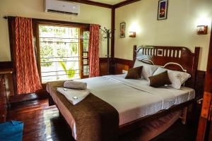 库玛拉孔Grand Villa Houseboat的带一张大床和一扇窗户的卧室