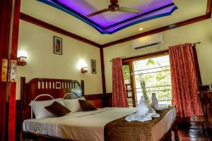 a bedroom with a bed with a ceiling at Grand Villa Houseboat in Kumarakom