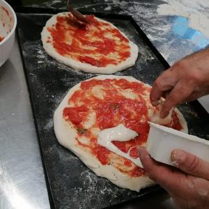 a person is making pizzas on a table at Fattoria di Cintoia in Pontassieve