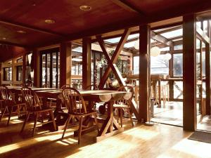 a dining room with a table and chairs and windows at ALP Lodge in Hakuba +55 photos