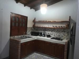 a kitchen with a sink and a stove and a refrigerator at dulce estancia in Jardin