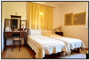 a bedroom with a bed and a desk and a mirror at Elegant Stone Mansion in Historic Mystras in Mystras
