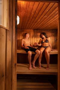 un hombre y una mujer sentados en una sauna en Village Vacances Le Mongade (by Popinns), en Plainfaing