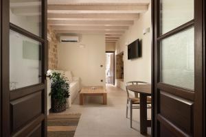 un corridoio con porta e tavolo in una stanza di San Antonio Luxury Apartments, Medieval Town a Città di Rodi