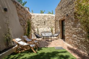 um pátio com cadeiras e uma mesa num edifício em San Antonio Luxury Apartments, Medieval Town in Ilha de Rhodes