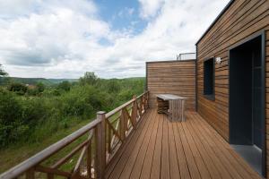 una terraza de madera con un banco en el lateral de un edificio en Lot en Dock 3 logements atypiques et écologiques en vallée de la Dordogne, en Souillac