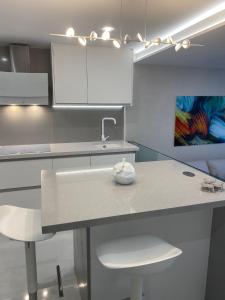 a kitchen with a sink and white cabinets at ocean experience / EXPERIENCE HOLIDAYS TENERIFE in Callao Salvaje +10 photos