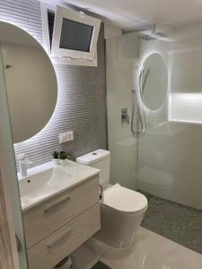 a bathroom with a toilet and a sink and a mirror at ocean experience / EXPERIENCE HOLIDAYS TENERIFE in Callao Salvaje