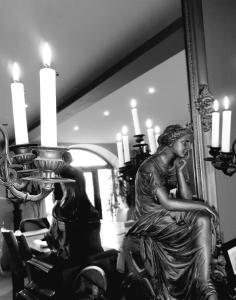 a statue of a woman sitting on a table in front of a mirror at Retour aux Sources in Gouberville