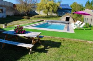 um quintal com uma mesa de piquenique e uma piscina em Chambres d'hôtes Aux Portes des Tumuli em Bussy-le-Château