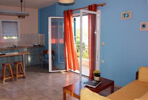 a kitchen and living room with an open sliding glass door at Koukounaries Apartments Limni in Límni