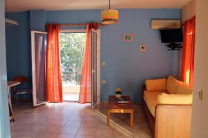 a living room with a couch and a table at Koukounaries Apartments Limni in Límni