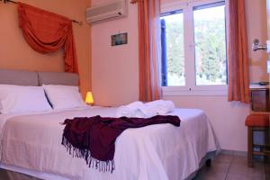 a bedroom with a bed with towels on it at Koukounaries Apartments Limni in Límni