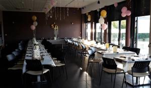 een eetkamer met witte tafels, stoelen en ballonnen bij Résidence Hôtelière des Ondes in Saint-Lys