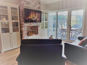 a living room with a fireplace and a couch at FeWo Pönblick in Willingen