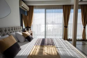 sypialnia z dużym łóżkiem i dużym oknem w obiekcie Carpe Diem Hotel w mieście Ayvalık