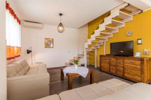 a living room with a couch and a tv and stairs at Villa Nada in Buje