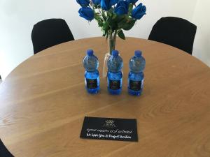einen Tisch mit drei Flaschen Wasser und einer Vase blauer Rosen in der Unterkunft QUEEN of the dead sea by CROWN in Neve Zohar