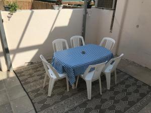 einen Tisch mit weißen Stühlen und einem blau-weißen karierten Tischtuch in der Unterkunft QUEEN of the dead sea by CROWN in Neve Zohar