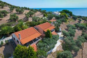 an aerial view of a house on a hill next to the ocean at Giola Bungalows Sirines in Astris