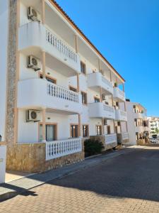 a building with balconies on the side of a street at Apartamento - 2 a 4 Pessoas- Piscina in Olhos de Água