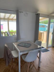 a white table and chairs in a room at Mobil home BASSET au camping à St Hilaire de Riez 400m de la mer in Saint-Hilaire-de-Riez