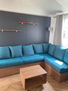 Sofá azul en la sala de estar con mesa de centro en Mobil home BASSET au camping à St Hilaire de Riez 400m de la mer en Saint-Hilaire-de-Riez