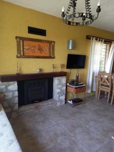 sala de estar con chimenea y TV en La Alquimia Casas de Campo en La Granja